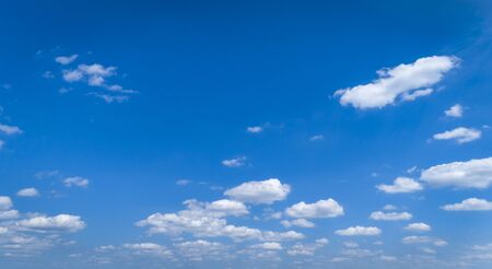 White Fluffy Clouds Floating in the Bright Blue Skies on a Summer Dayの写真素材