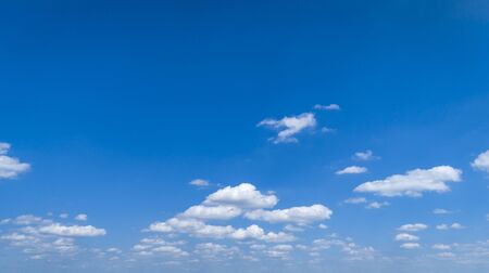 White Fluffy Clouds Floating in the Bright Blue Skies on a Summer Dayの写真素材