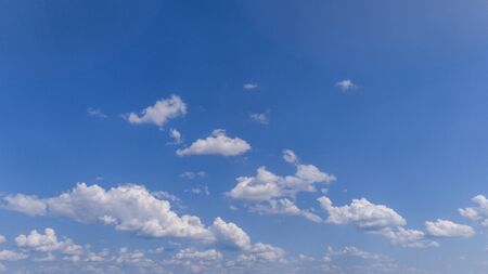 White Fluffy Clouds Floating in the Bright Blue Skies on a Summer Dayの写真素材