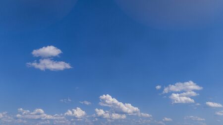 White Fluffy Clouds Floating in the Bright Blue Skies on a Summer Dayの写真素材