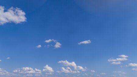 White Fluffy Clouds Floating in the Bright Blue Skies on a Summer Dayの写真素材