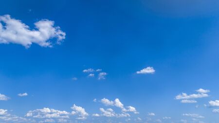 White Fluffy Clouds Floating in the Bright Blue Skies on a Summer Dayの写真素材