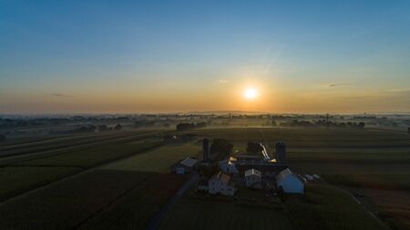 An Aerial View of a Sunrise Over an Amish Farm with Blues and Reds on a Clear Summer Morningの写真素材
