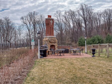 View of an Outdoor Brick and Stone Fireplace with Seating in the Gardenの写真素材