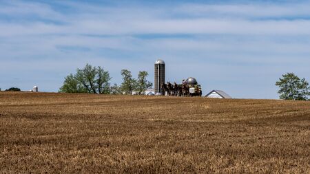 Amish Farmers Planting with 4 Horses on a Hill on a Sunny Spring Dayの写真素材
