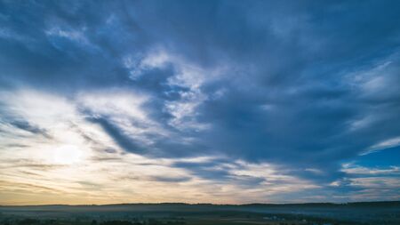 Aerial View of a Late Afternoon Sun With Partly Cloudy Blue Sky Over Farm Countryside Backgroundの写真素材