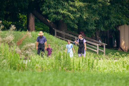 Ronks, Pennsylvania, July 2007 - Amish family, father and three daughters, walk along rail road tracks with dog on a sunny summer dayのeditorial素材