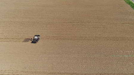 An aerial shot of donkeys pulling farming equipmentの写真素材