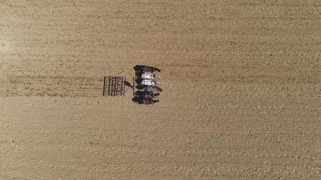 An aerial shot of donkeys pulling farming equipmentの写真素材