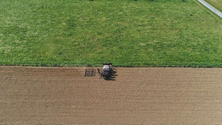 An aerial shot of donkeys pulling farming equipmentの写真素材