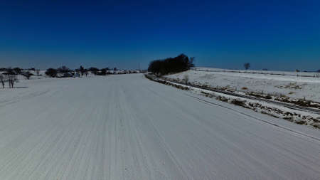 Fresh Snow Fall on a Farm Field with Rail Road Tracks on a Sunny Dayの写真素材