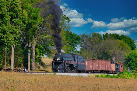 Strasburg, Pennsylvania, October 2019 - Antique Steam Freight Train Puffing Smoke and Steam While...