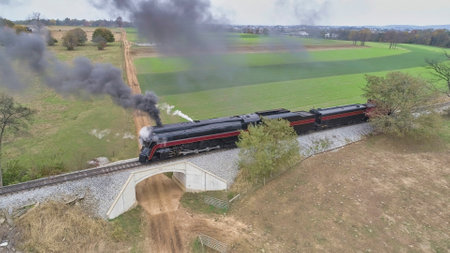 Aerial View of a Restored Antique Steam Locomotive Pulling a Caboose on a Sunny Fall Day