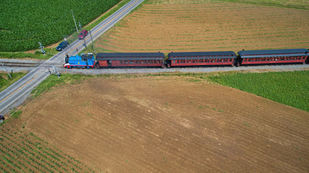 Ronks, Pennsylvania,June 2019 - Aerial View of Thomas the Tank Engine Approaching Thru Trees and Farmlands Pulling Passenger Cars Blowing Smoke on a Beautiful Summer Dayのeditorial素材
