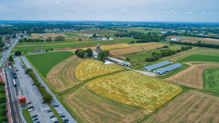 A Beautiful Aerial View of Farm Countryside with Patches of Colored Fields with White Fully Clouds and Shadowsの写真素材