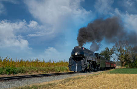An Antique Restored Steam Engine Approaching Head-on, On Some Old Rail Road Tracks Blowing Smoke and...