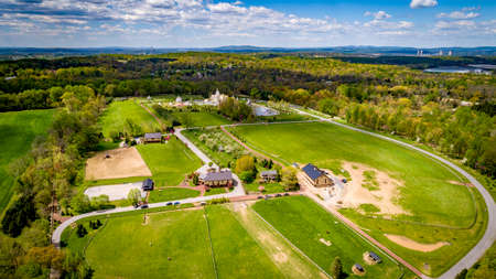 Aerial View of a Beautiful Countryside With Unique Barns and Farmhouses Meadows and Fields on a Sunny Dayの写真素材