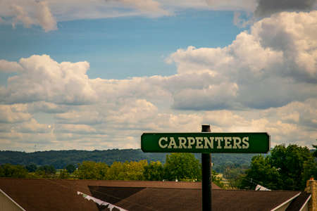 A Sign Post at a Railroad Crossing stating the Town on a Sunny Dayの写真素材