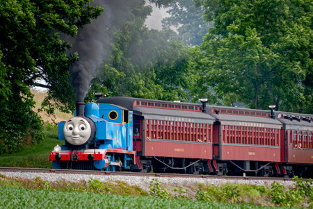 Strasburg, Pennsylvania. June 48 2021 - View of Thomas the Train Pulling Passenger Cars Blowing Smoke and Steam on a Sunny Dayのeditorial素材