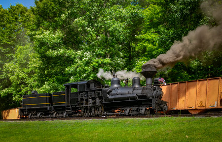 A View of an Antique Shay Steam Engine Warming Up, Blowing Smoke and Steam on a Sunny Dayの写真素材