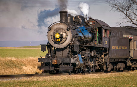 Ronks, Pennsylvania, December 30, 2022 - A Close Up View of a Classic Steam Passenger Train Approaching, Traveling Thru the Countryside, Blowing Smoke and Steam on a Winter Dayのeditorial素材