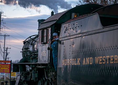 Strasburg, Pennsylvania, December 27, 2022 - A View of a Classic Steam Passenger Train Arriving into a Train Station Blowing Smoke and Steam, on a Winter Dayのeditorial素材
