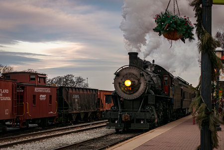 Strasburg, Pennsylvania, December 27, 2022 - A View of a Classic Steam Passenger Train Arriving into a Train Station Blowing Smoke and Steam, on a Winter Dayのeditorial素材