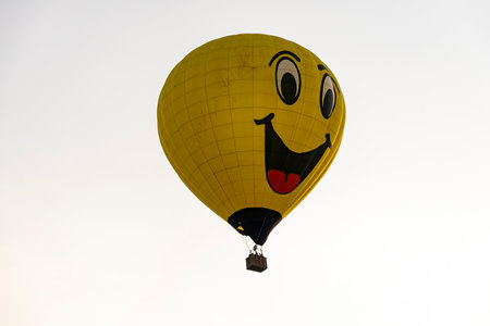 Bird in Hand, Pennsylvania, September 18, 2023 - A View of a Hot Air Balloon With a Happy Face on it Floating in a Blue Sky With Thin Cloudsのeditorial素材