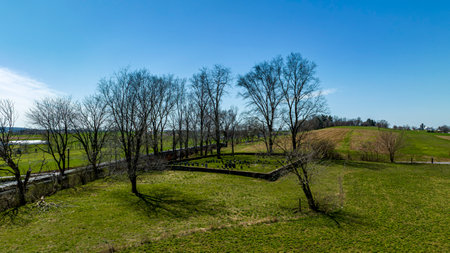 A Drone View of an Old Countryside Small Cemetery, Next to a Steam Passenger Train Passing By It, on a Sunny Spring Dayの写真素材