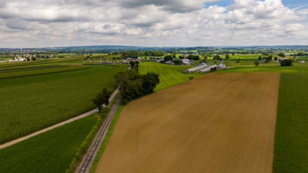 An Aerial View of Rural America, with Farmlands and a Single Rail Road Track Going Thru it.