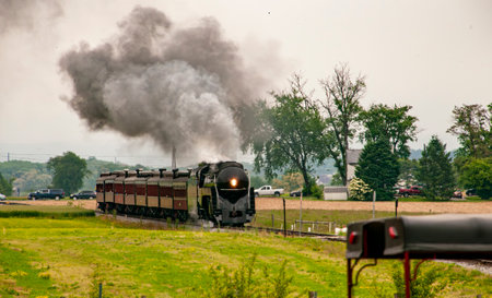 A View of an Antique Steam Passenger Train Approaching, Traveling Thru Rural Countryside on a Sunny Spring Dayの写真素材
