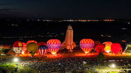 Bird in Hand, Pennsylvania, September 15, 2023 - An Aerial View of a Line of Performing Hot Air Balloons Glow on a Summer Eveningのeditorial素材