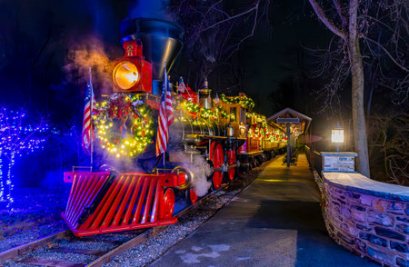 Elizabethtown, Pennsylvania, December 6, 2022 - A Close View of an Antique 1860s Steam Engine Steamed Up, all Decorated for Christmas, on a Clear Nightのeditorial素材