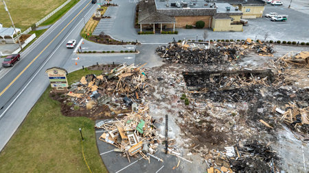 Bird in Hand, Pennsylvania, USA, September 14, 2023 - An Aerial View Of A Devastated Building Amidst Intact Structures With Cars On The Road And Green Fields In The Background Under A Cloudy Sky.のeditorial素材