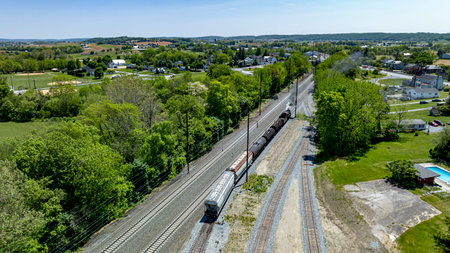 Aerial of a steam engine moving freight in yard to multiple rail tracks.