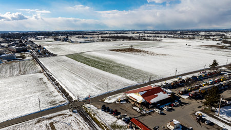Ronks, Pennsylvania, USA, February 17, 2024 - A snowy landscape with a red building in the background. The sky is clear and the snow is covering the groundのeditorial素材