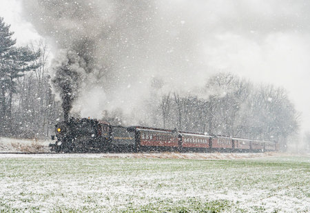 Ronks, Pennsylvania January 6, 2024 - In a picturesque winter scene, a historic steam train cuts through a heavy snowfall, its journey reminiscent of a classic winters tale.のeditorial素材