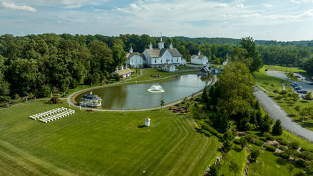 Elizabethtown, Pennsylvania, USA, August 11, 2023 - Aerial View Showcasing A Cluster Of Traditional White Orthodox Churches With Cross-Topped Domes, Arranged Around A Curved Pond With A Fountain, Amidst Green Trees And Neatly Arranged White Benchesのeditorial素材