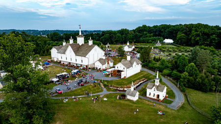Elizabethtown, Pennsylvania, USA, July 4, 2024 - Charming Rural Fairground With White Barns, Small Churches, Food Trucks, And People Enjoying Festivities Amidst Lush Greenery And Rolling Hills, Creating A Vibrant Community Gathering.のeditorial素材