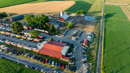 Ronks, Pennsylvania, USA, July 3, 2024 - Aerial View Of A Farm Event Featuring A Red Barn, Silo, Crowd, Food Trucks, Ample Parking, And Surrounding Fields With Railroad Tracks Nearby.のeditorial素材