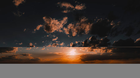 Golden sunlight breaks through clouds as the sun sets, creating a stunning display in the evening...
