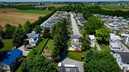 Residential Mobile, Manufactured, Prefab, Home Park with many houses and trees. The houses are white and the trees are green. The sky is cloudy and the houses are spread outの写真素材