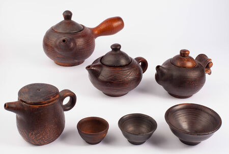 earthenware teapots and bowls isolated on whiteの写真素材
