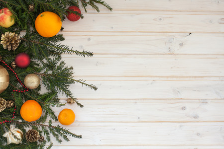 spruce branch with decoration and fruit on a white wooden backgroundの写真素材