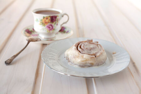 cinnamon roll and tea on the tableの写真素材