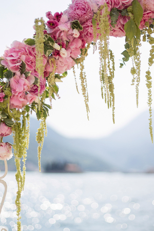 fragment of pink wedding arch of peons and hydrangea with a sea viewの写真素材