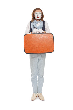 mime actor standing with orange suitcase in anticipationの写真素材