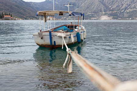 Fishing boat floating on the water tied to the shoreの写真素材