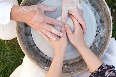 potter teaches the student the art of clay pottery