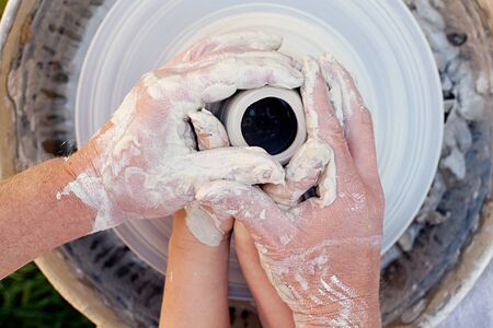 potter teaches the student the art of clay potteryの写真素材